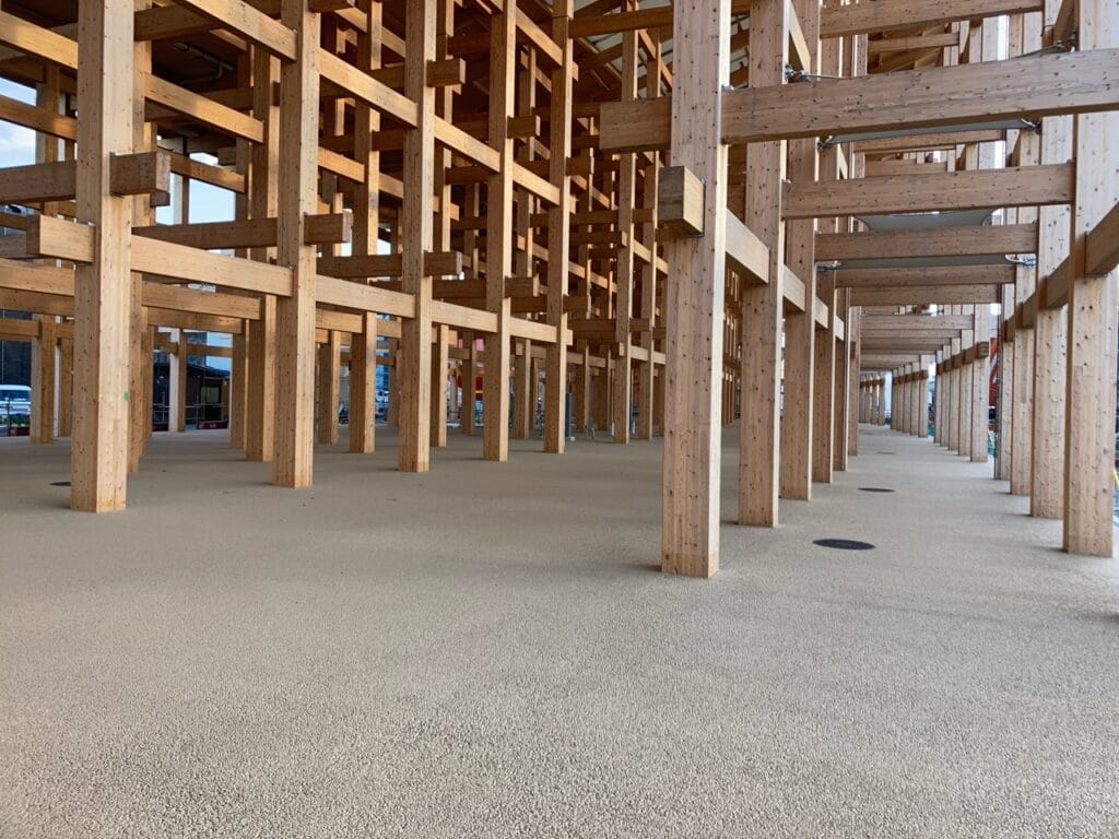Under-construction wooden framework with numerous vertical posts and crossbeams spanning a wide area.